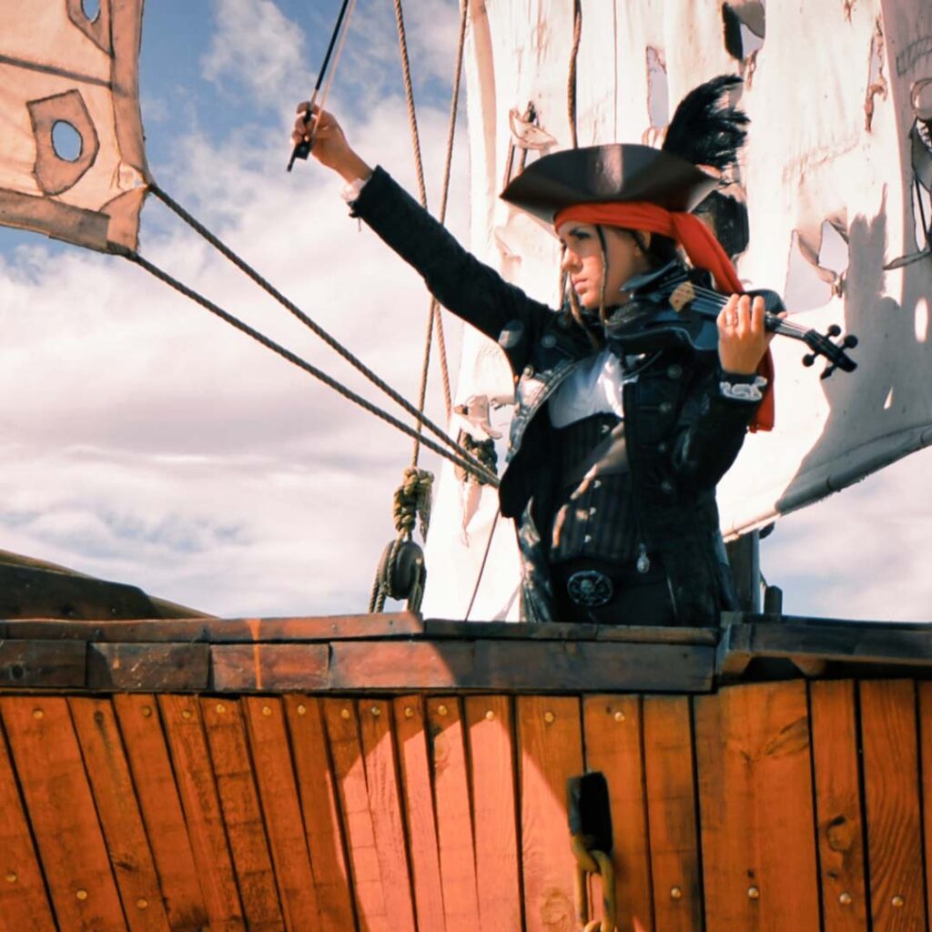 VioDance violinist on a pirate ship playing a carbon fiber violin and wearing a Pirates of the Caribbean costume